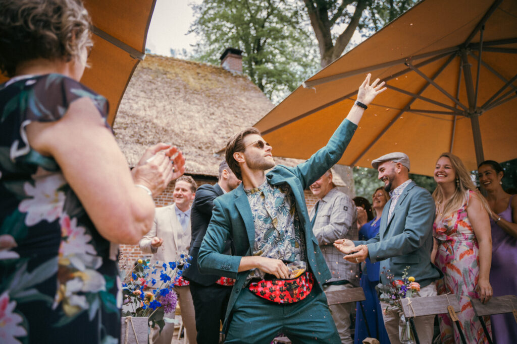Gasten juichen terwijl de bruidegom danst tijdens de ontvangst