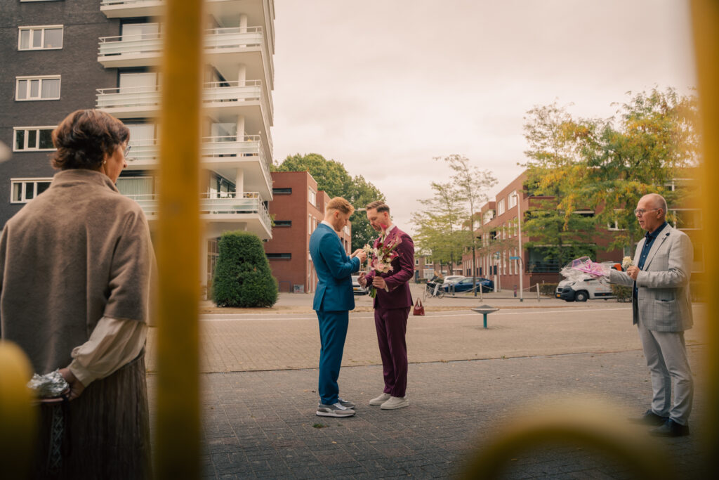Bruidspaar gezien door de spijlen van een hek